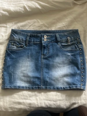Blå jeanskjol med nitar - jättesnyggggggg den passar någon som bär EU 34, har tyvärr inget måttband. lite stretchiga 