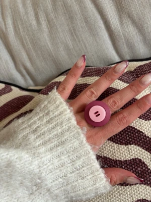 Ring med knapp - Säljer denna handgjorda ring.  Knapparna är vintage men själva ringen/ringstommen är helt ny och oanvänd. Materialet är rostfritt stål och varken tappar färg eller färgar av sig på huden. Ringen tål vatten. Storleken är justerbar, man kan trycka ihop och dra isär ringen till önskad storlek. Perfekt för dig som vill bära något unikt!