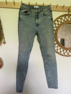 Ljusblå skinny jeans från Zara - Säljer ett par ljusblå skinny jeans från Zara med hög midja och klassisk femficksdesign. Jeansen har en smal passform och är tillverkade i stretchigt denimtyg för extra komfort. 