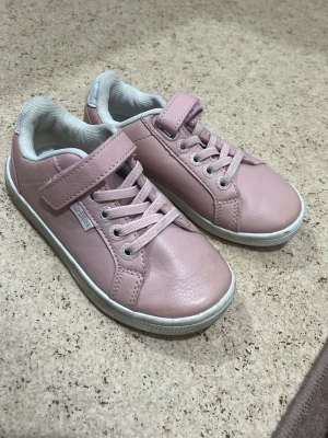 Rosa sneakers från Kavat - Snygga rosa sneakers från Kavat med klassisk låg profil. Skorna har vita sulor, elastiska skosnören och kardborreband för enkel påtagning. Tillverkade i slätt läder med vit textildetalj på insidan. Perfekta för en chill och stilren look.