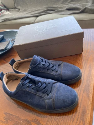 Mörkblå Christian Louboutin skor  - Slitna loubs med ett litet hål vid sidan.
