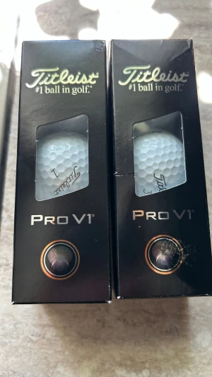 Titleist Pro V1 golfbollar 2st 3-pack - Två förpackningar Titleist Pro V1 golfbollar. Klassiska vita golfbollar i originalkartong, kända för lång distans, mjuk känsla och bra kontroll. Perfekt för dig som vill ha hög prestanda på golfbanan.