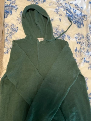 Grön hoodie från Studios i M - Mysig grön hoodie från Studios i storlek M. Hoodien har en klassisk huva med dragsko och är tillverkad i ett mjukt stickat material. Perfekt för dig som gillar en enkel och stilren look. Storlek m är den men tror den krympt lite så skulle tippa på s kanske✌🏻