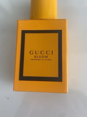Gucci Bloom Profumo di Fiori 30ml - Gucci Bloom Profumo di Fiori är en parfym i en snygg, fyrkantig gul flaska med svart ram runt etiketten. Doften är blommig och flaskan har en modern och stilren design som sticker ut på parfymhyllan.