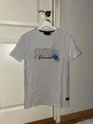 Vit Supply & Demand t-shirt - Vit t-shirt med tryck från Supply & Demand i storlek S. Fint skick den har aldrig kommit till användning 