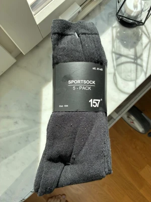 Svarta sportstrumpor 5-pack från 157 - 5-pack svarta sportstrumpor från 157 i storlek 41-45. Klassisk modell med ribbad kant upptill, perfekta till sneakers eller träningsskor. Tillverkade i mjukt och bekvämt material som passar till vardagens alla aktiviteter.