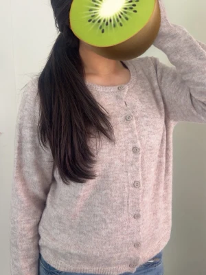 Ljusbeige stickad kofta - Mysig ljusbeige stickad kofta med rund halsringning och knappar framtill. Koftan har långa ärmar och ribbade muddar vid ärmslut och nederkant. Perfekt att slänga över en t-shirt eller linne för en skön look!💕