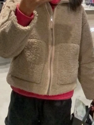Beige teddyjacka med dragkedja🐻🤎 - Mysig beige teddyjacka med två stora framfickor och dragkedja framtill. Jackan har en boxig passform och är gjord i fluffigt teddy-material som ger en trendig och avslappnad look. Perfekt för kyliga dagar och enkel att matcha med olika outfits.