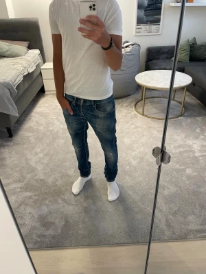 Dondup George jeans - Säljer ett par blå slim fit jeans med lätt slitna detaljer och klassisk femficksmodell från dondup. Jeansen har slim passform som sitter snyggt längs benen. Perfekta till en enkel t-shirt eller hoodie.
