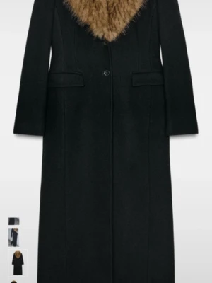 Svart ullrock med fuskpäls från ZARA - Stilren svart ullrock från ZARA med bred krage i brun fuskpäls. Lång modell med raka ärmar och två fickor framtill. Perfekt för dig som vill ha en klassisk men trendig look. Rocken stängs med en knapp framtill och har en exklusiv känsla tack vare materialmixen.