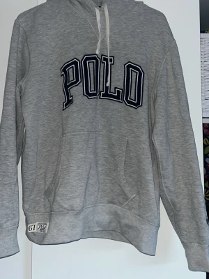 Grå hoodie från Polo Ralph Lauren - Snygg grå hoodie med stor POLO-text. Polo ralphalruen. Fint skicka inga flaws! 