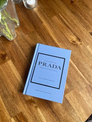 Lilla boken om Prada - En stilren, ljusblå inbunden bok.