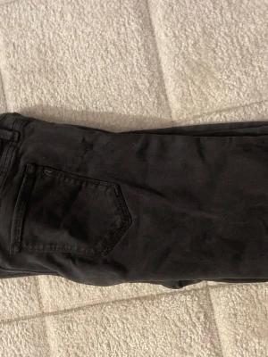 Svarta replay jeans - Säljer ett par svarta replay jeans med klassisk femficksdesign. Jeansen har en enkel och stilren look, perfekta till en avslappnad outfit. Materialet är mjukt och stretchigt för extra komfort.