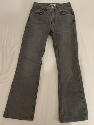 Grå Gina Jeans - Grå raka/vida jeans från Gina Tricot med medel/hög midja. Är inte använda särskilt mycket och därför väldigt bra skick. OBS jeansen är uppsydda nertill så håll koll på innerbenslängden MIDJEMÅTT: 34cm INNERBENSLÄNGD: 70cm