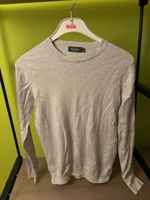 Ljusgrå tröja från Dressmann - Säljer en stilren ljusgrå tröja från Dressmann i mjuk Supima-bomull. Tröjan har rund halsringning och långa ärmar, perfekt för en clean och enkel look. Passar dig som gillar minimalistisk stil och sköna material.