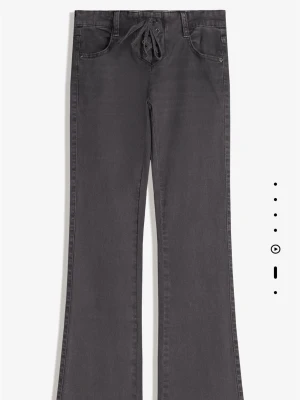 Utsvängda byxor 34 - Ett par utsvängda byxor med snörning och finns även en knapp på insidan. Den är lite mörk grå skulle jag säga. Helt nya och endast testade! Skulle säga att just denna är lite små i storleken💕