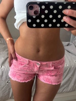 Lågmidjade rosa shorts med blommor - Såå fina rosa lågmidjade vintage jeansshorts med blommor! midjemått rakt över: 37. Jag är 168 och det är mina bilder, köp via köp nu direkt eller Swish, kvar tills markerad som såld 💖 