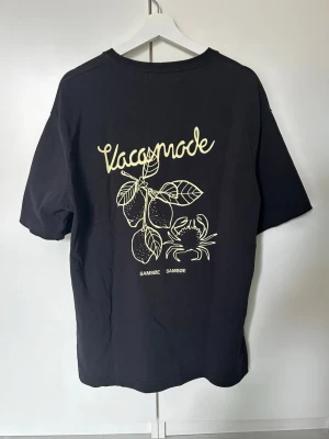 Svart t-shirt Samsøe Samsøe - Svart t-shirt från Samsøe Samsøe med tryck på bröstet och på ryggen. Oversized passform så passar även L. Perfekt för en chill och trendig look. Priset kan diskuteras och tveka inte vid minsta fundering!