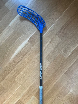 Unihoc superskin max 29 flex svart/mörkblå - Unihoc superskin max innebandyklubba i 29 flex. Klubban är 96 cm lång. På klubban sitter ett Unilite blad i bright blue PP-TI och en grå grepplinda. Den är aldrig använd men grepplindan och bladet är använda. Nypris ca 1500kr. Vid frågor eller funderingar är det bara att höra av sig. Pris kan diskuteras! 