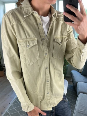 Jeansskjorta/overshirt  - Stilren och perfekt nu under sommaren! Färg beige/olivgrön. Mått: A:52 B:46 C:41 D:62 (cm) Skriv vid fundering 😇🙌
