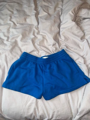 Blå bomullsshorts med resårmidja -Aritzia XS - Snygga blå shorts i mjuk bomull med elastisk midja och avslappnad passform. Perfekta för varma dagar eller när du vill chilla hemma. Klassisk modell utan mönster eller extra detaljer.