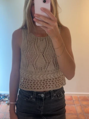 Beige stickad  topp från Zara - Superfin beige stickad linnetopp med snyggt virkat mönster och croppad passform från Zara. Storlek Small, ganska djup i ryggen. Passar så bra inför sommaren🤎