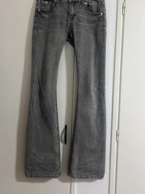 Grå bootcut jeans med fickdetaljer - Säljer ett par grå bootcut jeans från Gina tricot med snygga fickdetaljer i baksidan. 