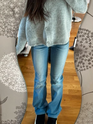 Ljusblå lågmidjade  bootcut jeans - Säljer ett par ljusblå lågmidjade bootcut jeans med snygg tvätt och klassisk femficksmodell. Jeansen har en något utsvängd passform nedtill och är perfekta för en avslappnad och trendig look. Materialet är mjukt denim som sitter bekvämt hela dagen. Midje: 35-36cm och innebenslängd: 74cm 🫶🏻