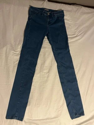 Filippa K Jeans Tajt Passform storlek S - Säljer ett par klassiska Filippa K-jeans i storlek S. De har en tajt, skinny-fit passform som sitter snyggt runt midja och lår, och är i bra skick utan hål eller fläckar. Färgen är en tidlös blå.