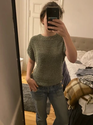 Grön stickad topp från Zara - Säljer en grön stickad topp från Zara i storlek S. Tröjan har korta ärmar, rund halsringning och ett luftigt, grovstickat mönster. Aldrig använd! Pris går att diskutera