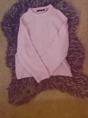 Ljusrosa stickad tröja - Mysig ljusrosa stickad tröja med rund halsringning och långa ärmar.