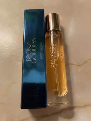 Estée Lauder Bronze Goddess Nuit parfym 10ml - Bronze Goddess Nuit från Estée Lauder är en elegant parfym i en smal glasflaska med guldigt lock. Doften kommer i en lyxig blå metallic-förpackning och flaskan har en varm bärnstensfärgad vätska. Perfekt för dig som gillar exklusiva och sensuella dofter. Testat ett spray!