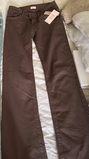 Bruna jeans från Nelly  - Säljer bruna jeans från Nelly, storlek 36, bootcut lågmidjade, helt nya, kom hem nyss men säljer då dom tyvärr var för stora, nerpackade i påsen igen redo att skickas, ny pris 599kr mitt pris 450kr