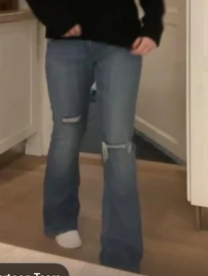 Blå bootcut jeans med slitningar - Säljer ett par blå bootcut jeans med hål som jag gjort själv. Vet inte storleken men skulle säga att de sitter som 38. Fråga för mått💕