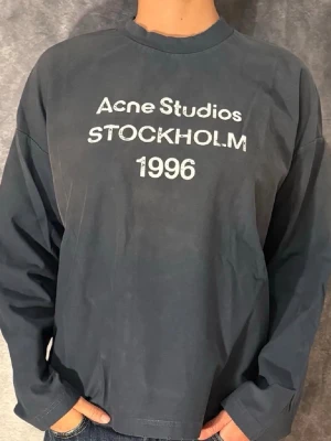 Acne studios longsleeve (navy/M) - Cool svart långärmad topp från Acne Studios med vit text 'STOCKHOLM 1996' framtill. Klassisk rund halsringning och rak passform. Perfekt till jeans för en clean och stilren look. Fraktar samma dag. Allt og ingår. Pris kan diskuteras ;)