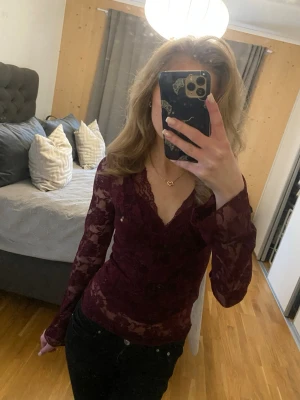 Vinröd spets topp -  Vinröd spets topp från ginatricot med långärm. Toppen har ett fint blommigt mönster och en v-ringad hals ringing. Jag har haft den ett tag men endast använt två gånger så den är i väldigt bra skick utan slitage. En perfekt fest topp.