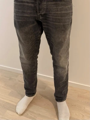 G-star Raw Jeans - Säljer ett par svarta jeans med snyggt tvättad finish och smal passform. Jeansen har klassisk femficksdesign, normal midja och avsmalnande ben. Perfekta för en avslappnad men ändå stilren look. Storlek W30 L30