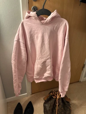 Ljusrosa hoodie från Gina Tricot - Säljer en ljusrosa hoodie från Gina Tricot, basically basics-kollektionen. Hoodien har en stor känguruficka framtill, huva och ribbade muddar vid ärmslut och nederkant. Perfekt oversized look och supermjuk bomullskänsla.🤍