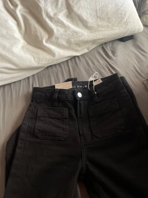 Svarta wide leg jeans från bikbok - Säljer ett par  svarta jeans från bikbok, modell Camille, coole wide leg passform och mid waiste.  Prislappet är fortfarande på och priset kan såklart diskuteras .