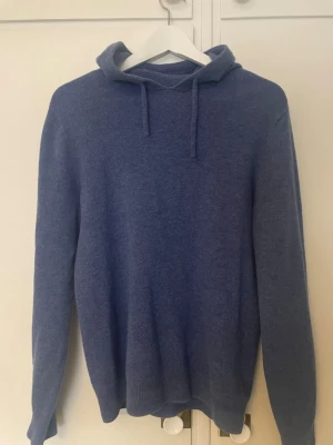 Merinoull Hoddie - En 100% merinoull Hoddie. En blå Hoddie som är väldigt skön och passar bra. Perfekt för våren och en sommar kväll.