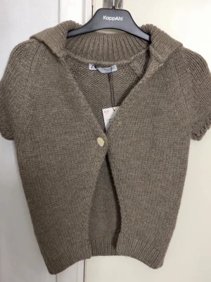 Zara kofta  - Supersöt stickad kortärmad kofta ifrån Zara med knapp. Helt oanvänd med lappen kvar. Strl S