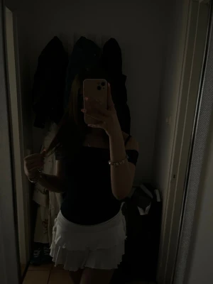 Marinblå offshoulder topp - Trendig offshoulder topp med smal passform och axelbandslös design. Perfekt att matcha med kjol eller jeans för en snygg och enkel look. Tidlös och enkel att styla till olika outfits. Använd bara 1 gång!