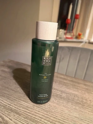 Rituals The Ritual of Jing badskum - Lyxigt badskum från Rituals, The Ritual of Jing, med doft av lotusblomma och jujube. Flaskan är grön med elegant vit kork och rymmer 500 ml. Perfekt för dig som vill ha en avkopplande stund med mjukgörande och väldoftande bad.