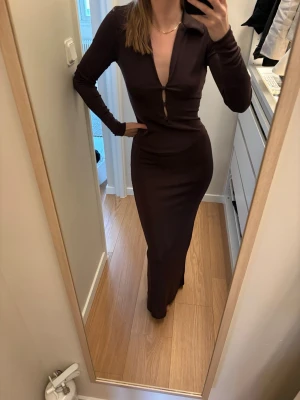 Brun långklänning - Snygg och smickrande klänning från NA-KD. Så fin men kommer inte till användning, så är i fint skick. Storlek S. En slits där bak och öppning med knappar vid bysten. Helt slutsåld. Nypris 599kr. Frakt tillkommer💞💞🫶🌸🪩