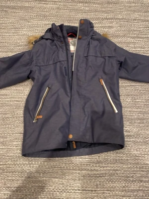 Reima Vinterjacka barn - Riktigt skön vinterjacka till barn. Mycket fint skick med päls. Storlek 140. Priset är inte hugget i sten. Nypris ca 1000kr Har ett litet problem med dragkedjan men är inget som syns eller gör skillnad (se sista bilden)