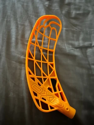 Orange innebandyblad från Oxdog - Säljer ett orange innebandyblad från Oxdog med ett öppet rutmönster och böjd form. Bladet är tillverkat i plast och har detaljerat mönster samt logga på sidan. Perfekt för dig som vill byta blad på din klubba. Avox blad i höger. helt nytt typ. Nypris 400kr, 
