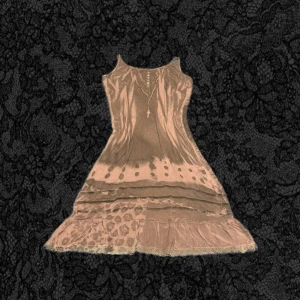 klänning från Funky Fig - Supersöt rosa/grå klänning från Funky Fig med  tunna axelband. Klänningen har ett coolt mönster och volangkant nertill. Perfekt för dig som gillar en unik och 2000- stil.