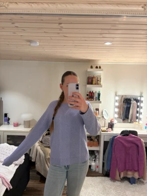 Ljuslila stickad tröja - Mysig ljuslila stickad tröja med rund halsringning och långa ärmar. Tröjan har en enkel och stilren design med ribbstickade muddar vid ärmslut och nederkant. Perfekt för lager-på-lager och passar till jeans eller kjol.