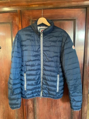 Colmar jacka - Säljer en snygg och tidlös Colmar-jacka i klassisk design. Jackan är använd och har tecken på slitage. Det finns en lagning på ryggen samt allmänt bruksslitage, vilket syns på nära håll. Inget som påverkar funktionen – jackan är fortfarande varm, bekväm och fullt användbar, men prissatt därefter. Perfekt för dig som vill ha en äkta Colmar-jacka till ett bättre pris och inte har något emot lite patina. 