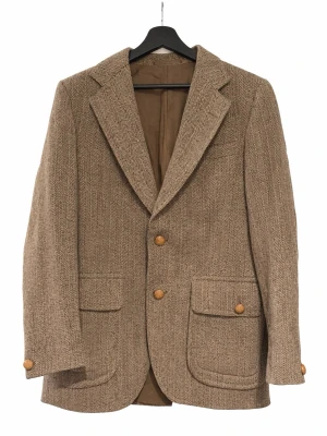 Vintage Burberry Tweed-kavaj - Väldigt fin klassisk vintage-kavaj från Burberry med brun tweed i fiskbensmönster. Tillverkad i England, 100% ull, helfodrad i viskos. Mycket hög kvalitet!                                                                          Herr. När kavajen tillverkades inkluderande Burberry inte storlekslappar i plaggen. Uppskattad storlek: M / 48. Mått: Bröstvidd: ca 49,5cm (mätt rakt över), Rygglängd ca 74cm. Bra vintage skick med normalt bruksslitage.